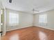 Spacious bedroom featuring wood floors, ceiling fan and large windows at 2242 Orkney Dr, Leesburg, FL 34788