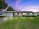 Charming single-story home features a well-manicured lawn, attached garage, and neutral-colored exterior at 2242 Orkney Dr, Leesburg, FL 34788