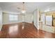 Open living room featuring wood floors, chandelier and access to kitchen at 2242 Orkney Dr, Leesburg, FL 34788