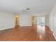 Spacious living room featuring hardwood floors, a ceiling fan, and easy access to other living spaces at 2242 Orkney Dr, Leesburg, FL 34788