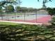 Well maintained tennis court with a green and red surface surrounded by a chain link fence at 2242 Orkney Dr, Leesburg, FL 34788