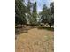 Expansive backyard view featuring mature trees and the rear of the home with a covered porch at 23130 Brouwertown Rd, Howey In The Hills, FL 34737