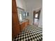 Bathroom with a dual-sink vanity, black and white checkerboard tile floor and wooden cabinets at 23130 Brouwertown Rd, Howey In The Hills, FL 34737