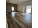 Spacious living room features wood-look flooring, large windows and a ceiling fan at 23130 Brouwertown Rd, Howey In The Hills, FL 34737