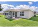 Backyard with a screened patio offering an ideal outdoor living space, surrounded by well-maintained green grass at 2369 Five Forks Trl, The Villages, FL 32162