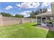 Backyard features a screened patio beside a grassy yard enclosed by a stucco wall for privacy and outdoor enjoyment at 2369 Five Forks Trl, The Villages, FL 32162