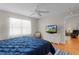 Bright bedroom features a ceiling fan, a window, and dresser with television at 2369 Five Forks Trl, The Villages, FL 32162
