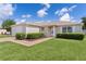 Inviting front entrance with manicured bushes and a well maintained lawn at 2369 Five Forks Trl, The Villages, FL 32162