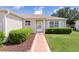 Inviting front entrance with manicured bushes and a well maintained lawn at 2369 Five Forks Trl, The Villages, FL 32162