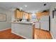Bright kitchen featuring white appliances, wood cabinets, hardwood floors and bar seating at 2369 Five Forks Trl, The Villages, FL 32162