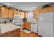 Bright kitchen featuring white appliances, wood cabinets and hardwood floors at 2369 Five Forks Trl, The Villages, FL 32162