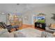 Open-concept living room featuring hardwood floors and a flat screen TV at 2369 Five Forks Trl, The Villages, FL 32162