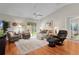 Cozy living room with vaulted ceiling, sliding door access to screened lanai, and comfortable seating at 2369 Five Forks Trl, The Villages, FL 32162
