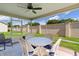Screened lanai with seating for four and a view of the landscaped backyard and block fence at 2369 Five Forks Trl, The Villages, FL 32162