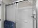 Shower featuring sliding glass doors, white tile surround and shower head at 2369 Five Forks Trl, The Villages, FL 32162