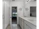 Bright bathroom with dual sinks, white cabinets, quartz countertop, and glass-enclosed shower at 23707 Companero Dr, Sorrento, FL 32776