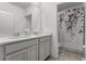 Bright bathroom featuring double sinks, light grey cabinets, and decorative shower curtain at 23707 Companero Dr, Sorrento, FL 32776