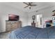 Spacious bedroom featuring a TV, dresser, ceiling fan and adjacent doorway to the bathroom at 23707 Companero Dr, Sorrento, FL 32776