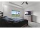 Comfortable bedroom featuring a ceiling fan, television and large window with picturesque view at 23707 Companero Dr, Sorrento, FL 32776