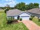 Aerial shot of a well-kept home with a green lawn, a brick driveway, and a convenient two-car garage at 23707 Companero Dr, Sorrento, FL 32776
