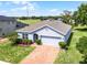 Aerial view showcasing a well-maintained home with a lush green lawn, brick driveway, and a two-car garage at 23707 Companero Dr, Sorrento, FL 32776