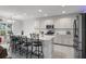 Bright kitchen featuring white cabinetry, a large center island with barstool seating, and stainless steel appliances at 23707 Companero Dr, Sorrento, FL 32776
