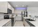 Modern kitchen with white cabinets, stainless steel appliances, and a center island with a farmhouse sink at 23707 Companero Dr, Sorrento, FL 32776