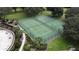 Aerial view of well-maintained tennis courts surrounded by lush landscaping, showcasing the community's recreational amenities at 23707 Companero Dr, Sorrento, FL 32776
