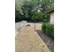 A chain-link fence secures this large backyard, partially covered in dry grass and shaded by mature trees at 2421 Centennial Blvd, Leesburg, FL 34748