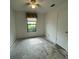 Bedroom with a single window and a door, featuring blank walls and no flooring at 2421 Centennial Blvd, Leesburg, FL 34748