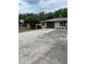 Modest single-story home with a driveway and a one car garage surrounded by landscaping and trees at 2421 Centennial Blvd, Leesburg, FL 34748