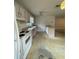Outdated kitchen with white cabinets, tile flooring, standard appliances, and a view into the dining area at 2421 Centennial Blvd, Leesburg, FL 34748
