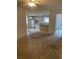 Open concept living area with kitchen access, and bare floors ready for renovation at 2421 Centennial Blvd, Leesburg, FL 34748