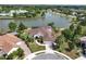 Aerial shot of a large home with well manicured lawn near a lake and clubhouse at 2457 Bar Harbor, Mount Dora, FL 32757