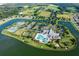 Aerial view of a community featuring a pool, tennis courts, clubhouse, and well-manicured landscaping at 2457 Bar Harbor, Mount Dora, FL 32757