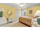 Bright bedroom features yellow walls, white trim, and a floral-patterned quilt on the bed at 2457 Bar Harbor, Mount Dora, FL 32757