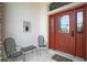 Cozy front porch with seating, showcasing an inviting entrance with a decorative door and sidelights at 2457 Bar Harbor, Mount Dora, FL 32757