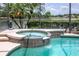 A relaxing hot tub next to the screen enclosed pool, offering a perfect spot to unwind and enjoy the water view at 2457 Bar Harbor, Mount Dora, FL 32757