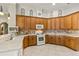 Spacious kitchen with wood cabinets, tile backsplash, and stainless steel appliances at 2457 Bar Harbor, Mount Dora, FL 32757