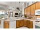 An open kitchen with tile floors, wood cabinets, and view of the living room at 2457 Bar Harbor, Mount Dora, FL 32757
