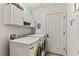 Convenient laundry room featuring modern washer and dryer, white cabinets, and a neatly organized space at 2457 Bar Harbor, Mount Dora, FL 32757