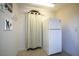 View of mud room area with white refrigerator and accenting design touches with curtains and wall decorations at 2457 Bar Harbor, Mount Dora, FL 32757
