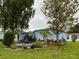 Backyard featuring a patio set, and plants, with a view of the house, trees, and grass at 24841 Pine Hl, Leesburg, FL 34748