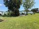 Spacious lawn surrounded by landscaping and other mobile homes at 24841 Pine Hl, Leesburg, FL 34748
