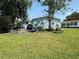 Green backyard with patio furniture, mature trees and grass at 24841 Pine Hl, Leesburg, FL 34748