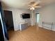 Open bedroom with a ceiling fan, television, and wood-look flooring at 24841 Pine Hl, Leesburg, FL 34748