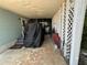 Enclosed carport area with covered furniture, bike, and lattice panels at 24841 Pine Hl, Leesburg, FL 34748