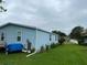 The home's blue siding is complemented by vibrant flower beds and lush green grass, enhancing the property's appeal at 24841 Pine Hl, Leesburg, FL 34748