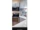 Updated kitchen features stainless steel oven and microwave, white countertop, and gray cabinets at 24841 Pine Hl, Leesburg, FL 34748