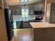 Bright kitchen featuring stainless steel appliances, gray cabinetry, and a farmhouse sink at 24841 Pine Hl, Leesburg, FL 34748